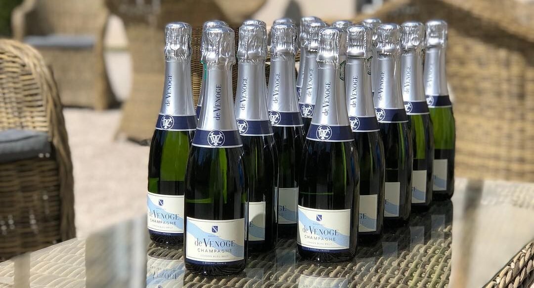 Foto mostra mesa com várias garrafas de champagne De Venoge. Foto Divulgação
