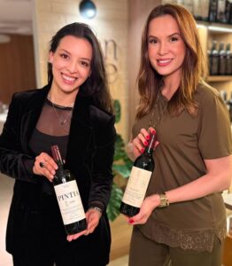 Thalita Garcia, embaixadora da Vega Sicilia no Brasil, e Francielly Ramos, da Gran Cave, seguram garrafas de vinho